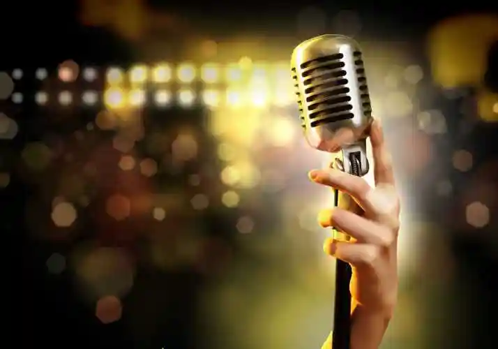 对五颜六色的背景下手拿麦克风的人