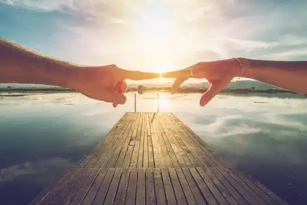 两根手指在晨曦中相碰照片摄影图片