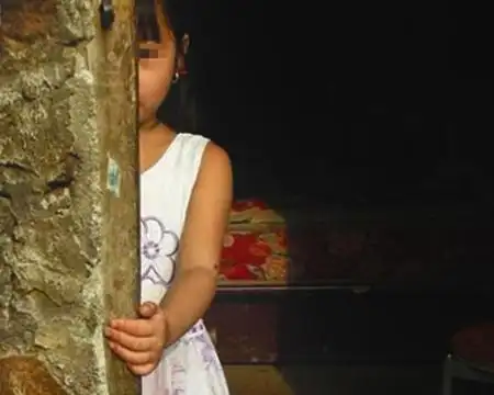 怀中的小女孩身体裹着一件大人的衣服,脚上仅穿了一双袜子.