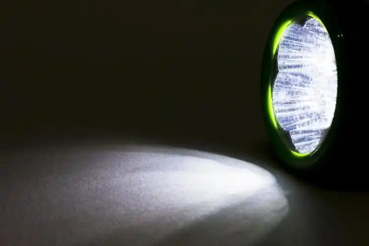 裹着被子拿着手电筒的女孩