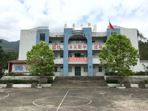 以前挂在半山腰的一排学校瓦房如今换成了崭新的有围墙的学校