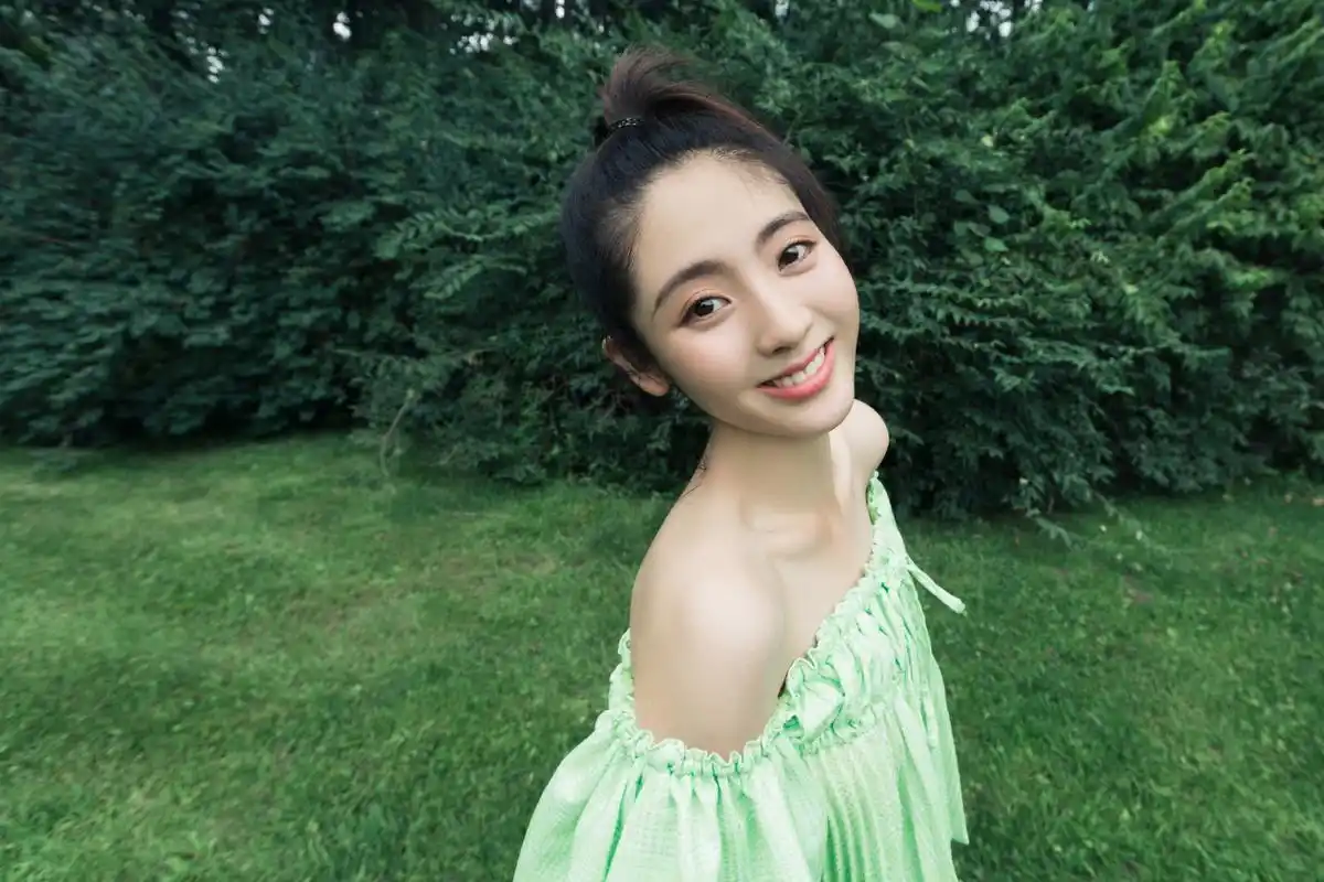 邢菲一组生日写真释出,一字肩绿色长裙搭配清爽马尾和明朗微笑