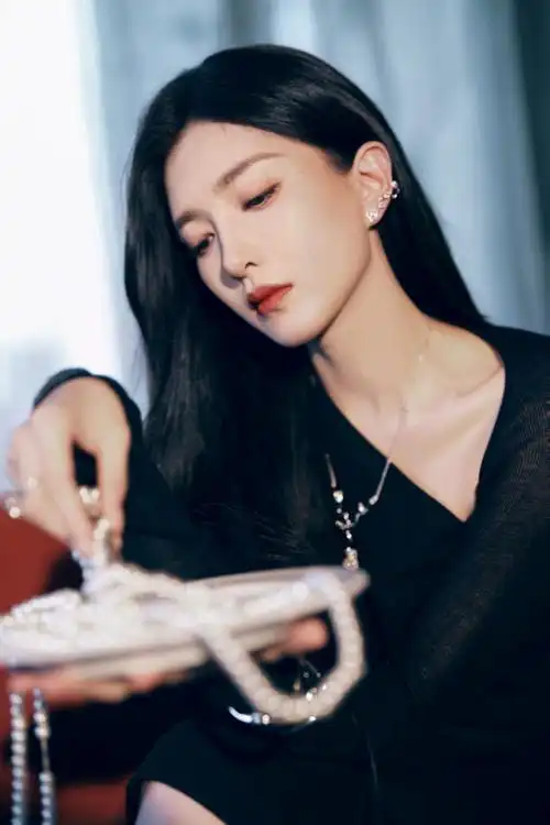 江疏影身穿黑色蕾丝斜肩裙,头发黑长直,妆容简约高级,一抹红唇气场