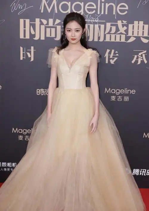 陈钰琪身材玲珑有致,身穿一件暖黄色的晚礼服,雍容华贵,晚礼服肩部和