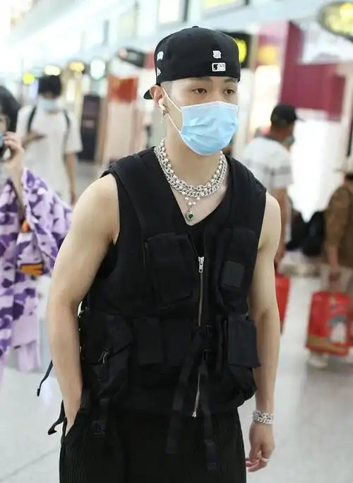 北京,马伯骞亮相机场,他身穿黑色无袖马甲秀出手臂肌肉,反戴棒球帽酷