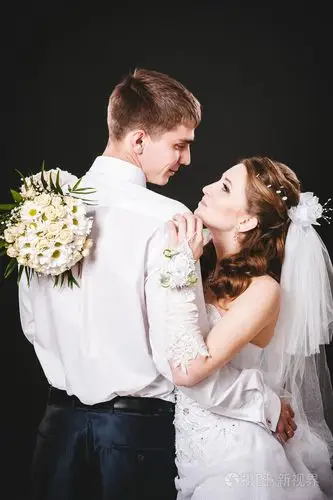 新郎在婚礼上亲吻新娘.黑色背景