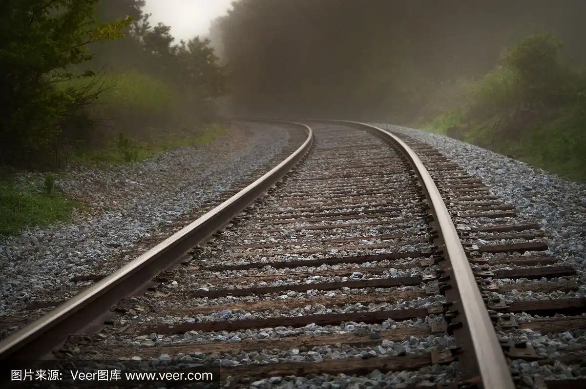 金属火车的轨道在雾中转弯