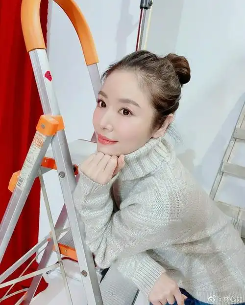 照片中,林心如斜倚着梯子,穿着高领毛衣,扎丸子头,妆容精致,状态非常