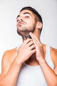 年轻英俊的男人,修剪他的胡子照片