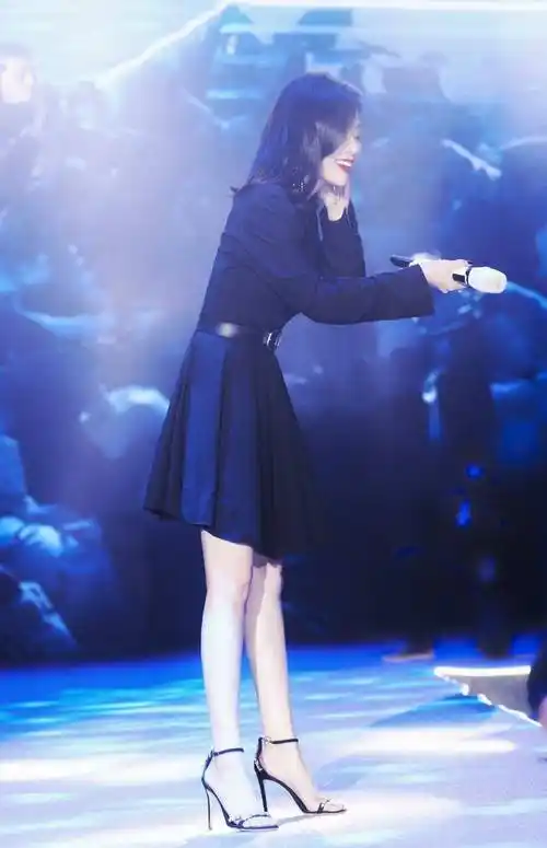 张靓颖搭配高跟凉鞋,让双腿看起来笔直匀称,带钻的一字带高跟鞋,营造