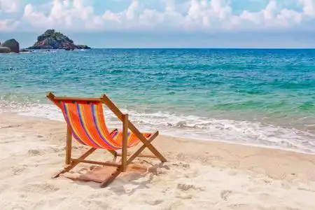 地平线上湾海湾的沙滩上休闲椅照片