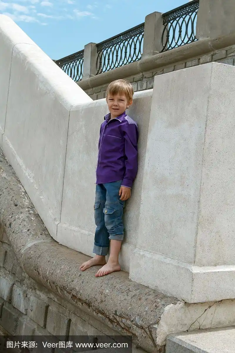 男孩光着脚在墙上爬