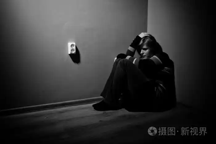 伤心女人独自坐在一个空的房间-黑色和白色照片-正版商用图片1bcog1