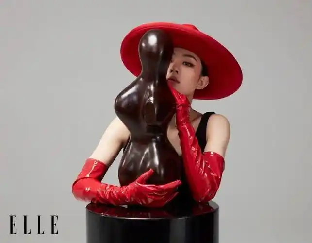 赵丽颖身穿黑色吊带上衣,胳膊戴着红皮手套头顶红色帽子,她俏脸冷艳