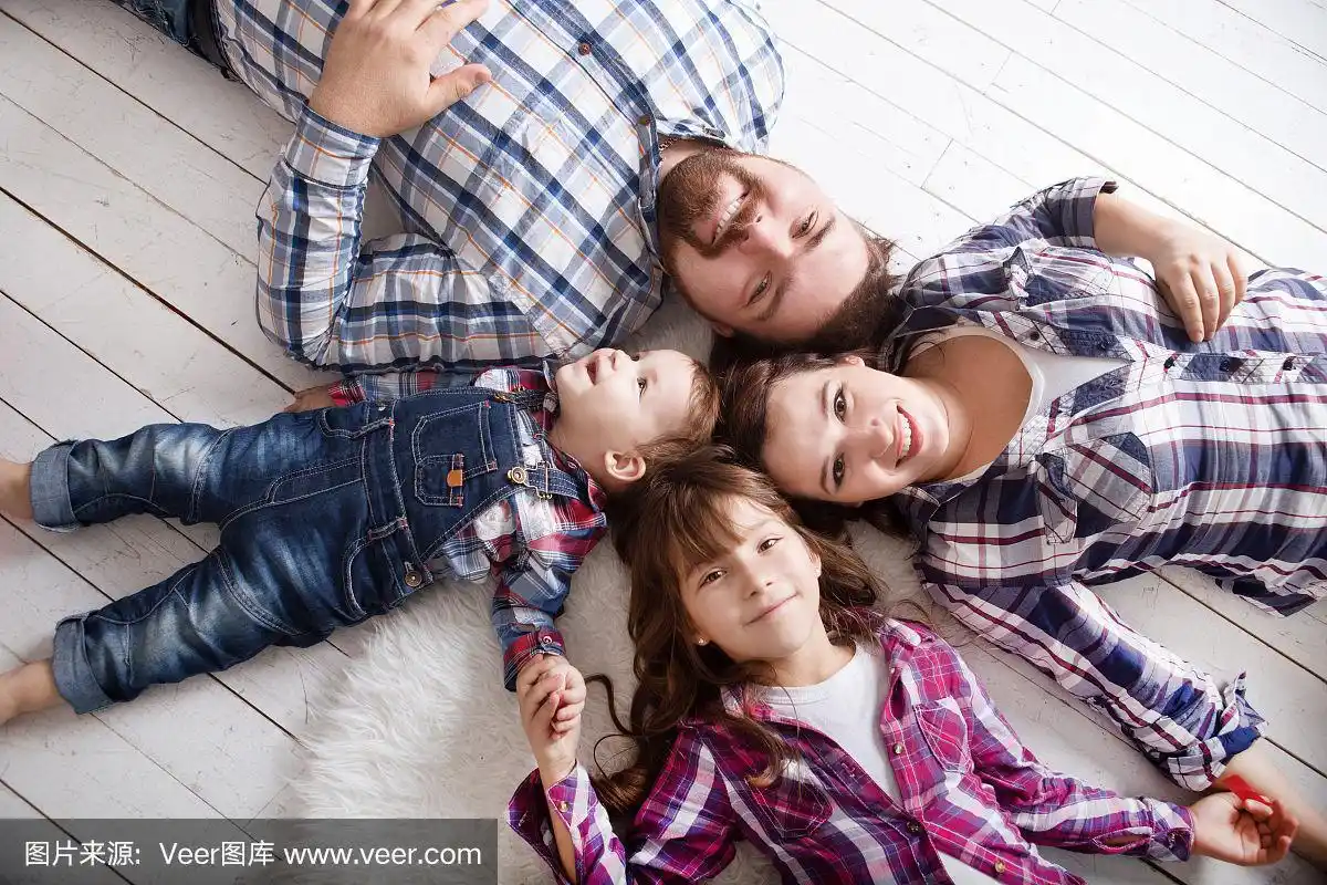 肖像幸福的家庭妈妈,爸爸和两个孩子在家里玩