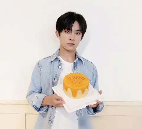 易烊千玺也是手捧蛋糕,穿了一件牛仔服,搭配白t恤,看起来青春洋溢