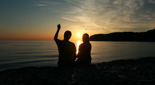 浪漫的情侣日落时坐在海边的沙滩上约会视频素材