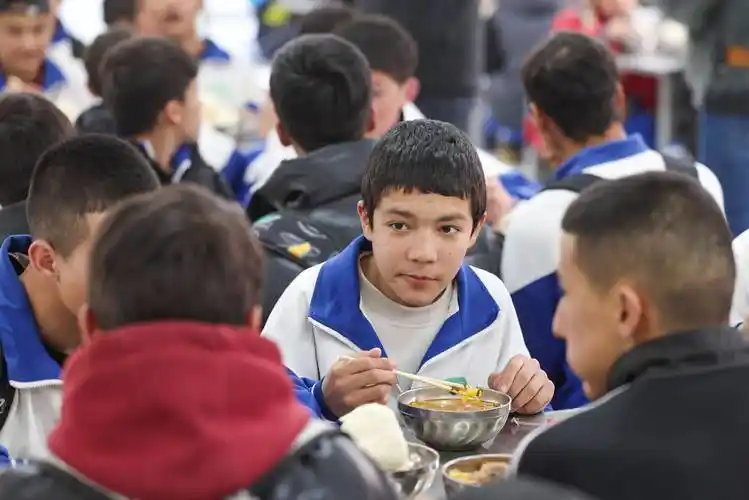 西合休乡初中生返校的车队抵达叶城县第十五中学,学校食堂早已为学生