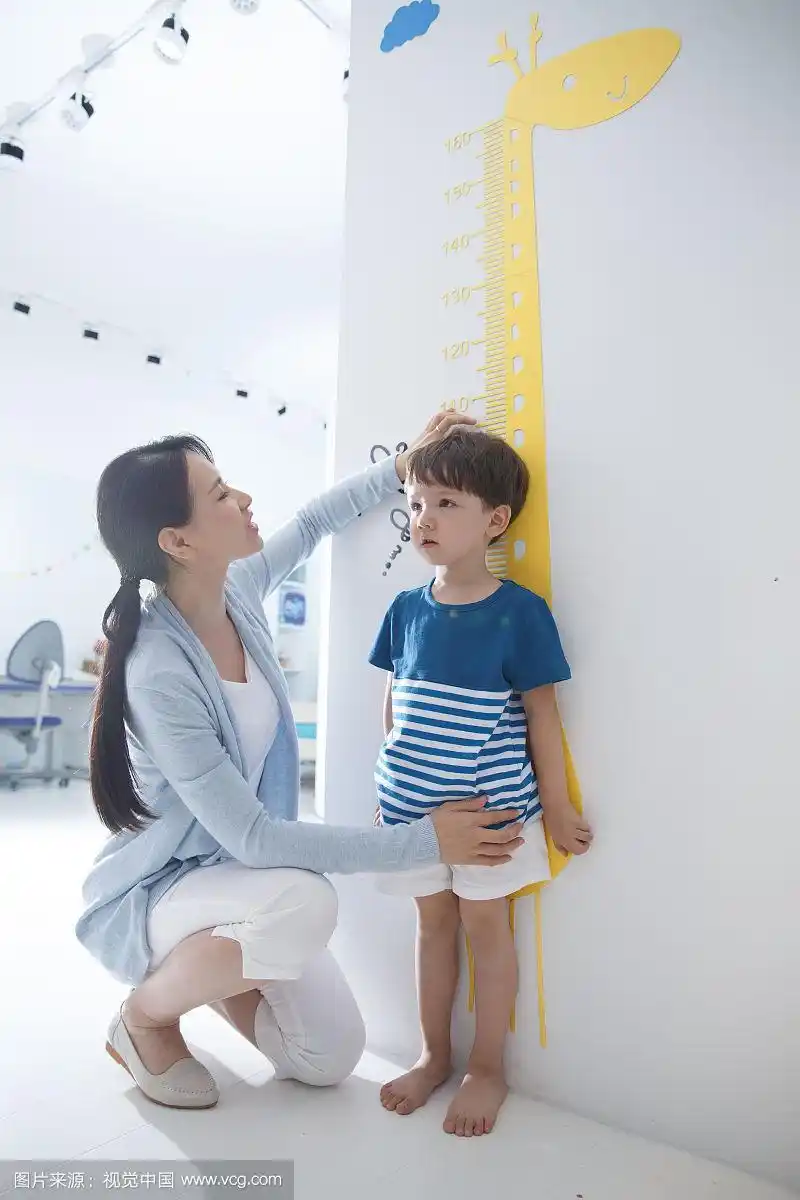 青年女人在为小男孩测量身高