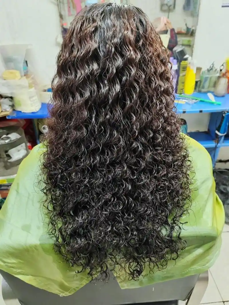 【理发店老板用热毛巾给顾客烫满头卷发】5月9日,山东淄博.