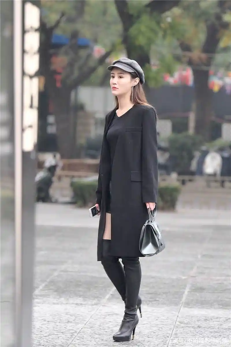 黑色细高跟过膝长靴,修身款式,搭配黑色风衣,时尚抢眼
