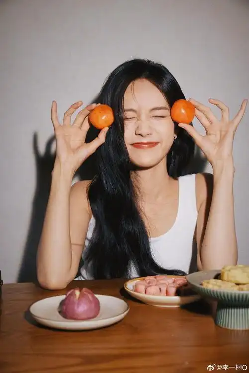 李一桐穿白衣清纯可人 手捧柿子笑容甜美