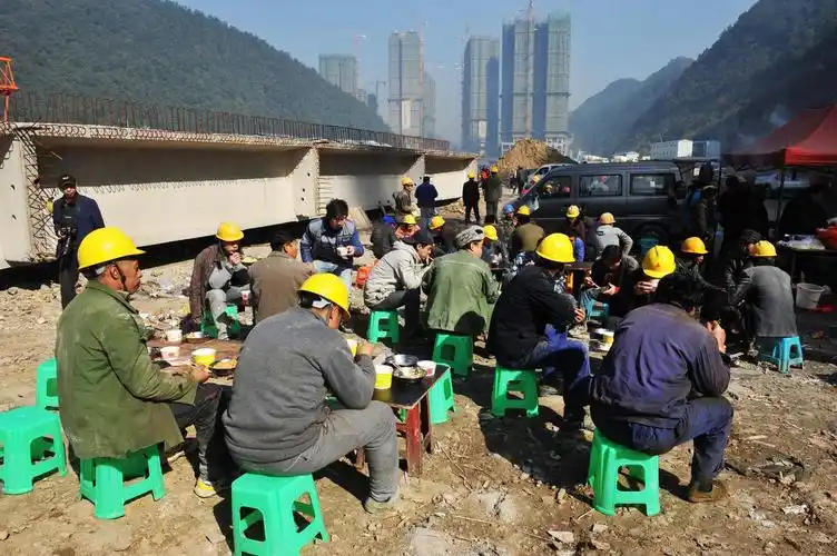 12月29日,在贵阳市一楼盘工地,数百名建房农民工在寒风中就地午餐.