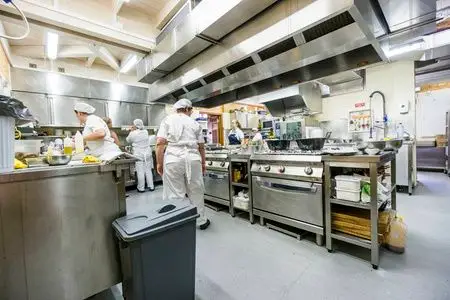 厨房工作人员忙于准备食物在午餐时间在餐厅照片