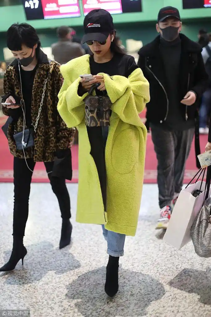 吉克隽逸黄色外套半脱潮范十足 踩细高跟玩手机气定神闲