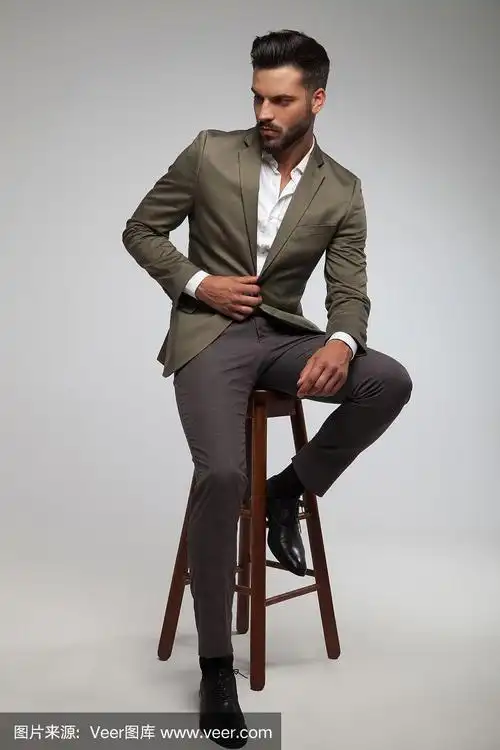 绿色西装的帅哥坐在木凳上
