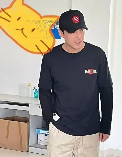 能够看到,胡歌里面穿了一件黑色t恤,外面套着剧组的短袖,头上还戴了一