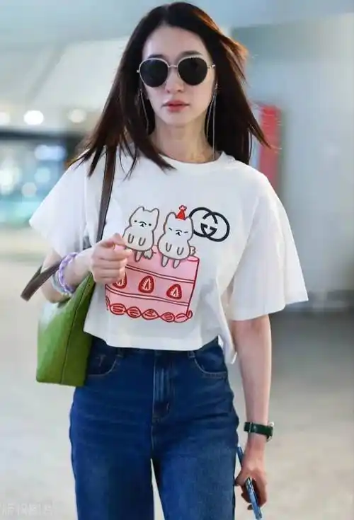冷白皮的李小冉机场造型很清新,白色卡通t恤衫搭配蓝色牛仔裤,时髦