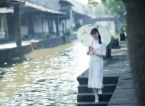 那江南女子,穿了丝绸的旗袍,撑着一把油纸伞,行走在白墙青石