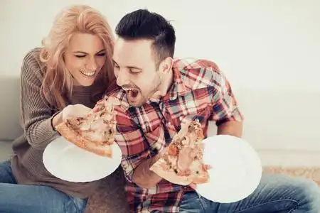 对夫妇吃苹果对夫妇吃比萨饼小吃照片