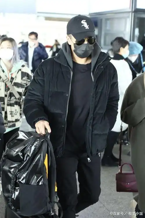 刘恺威自推行李大步赶路显繁忙,戴帽配墨镜造型低调十足