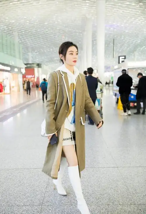 袁姗姗驼绒大衣走机场,长靴针织短款好时髦,大冬天秀出长腿冻人