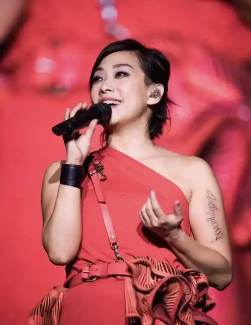 林忆莲越老越时髦,穿红色斜肩上衣化烟熏妆演唱,手臂粗也不怕_黑色