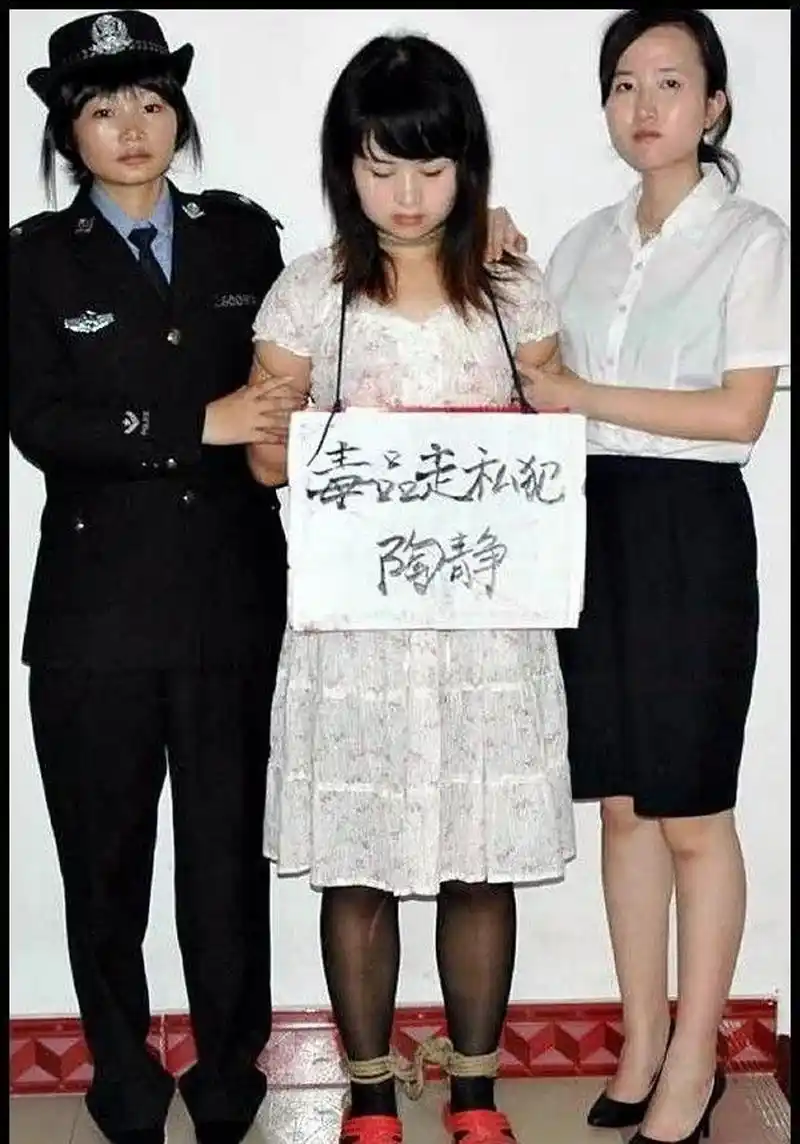 这张图片拍摄的是一个女毒贩,被绑上了法绳,即将押往刑场的情景,她一