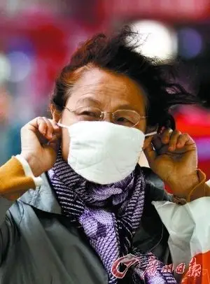 风中凌乱 一位阿姨戴紧口罩御寒风.记者庄小龙摄
