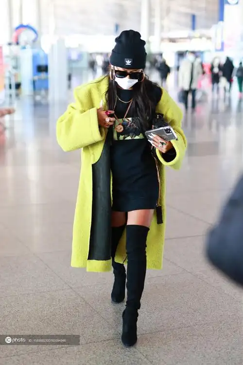 街拍吉克隽逸黑色卫衣裙过膝长靴黄色羊绒大衣毛线帽个性亮眼