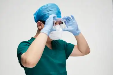 穿手术服戴手术帽护目镜手术手套的男性医生