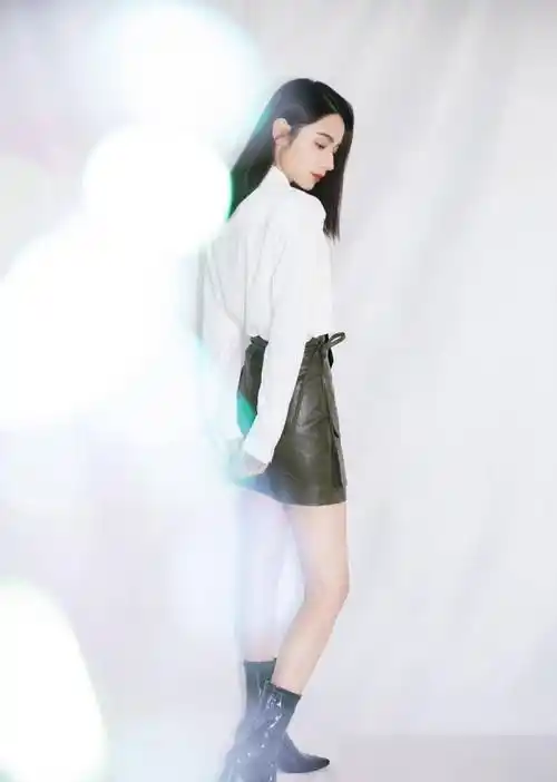 代斯上身穿白色衬衫,系上黑色波点领带,搭配暗红色半身皮质短裙,直接