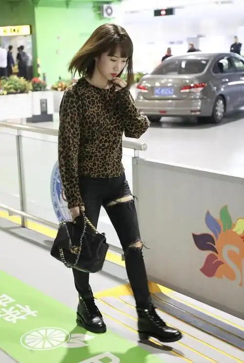 照片中,李念穿着一件豹纹上衣,搭配一条破洞牛仔裤,打扮的非常时尚