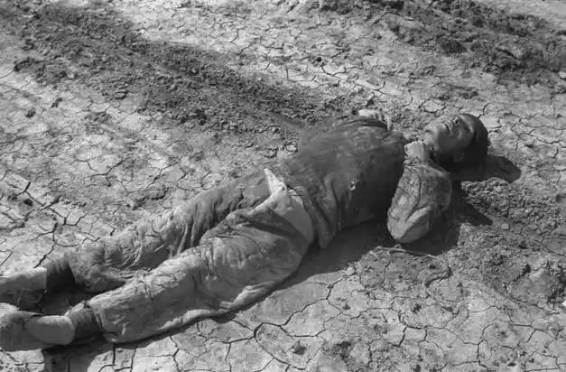 民国时期,一名饿死在路边的饥民照片,骨瘦如柴躺在干裂的土地上