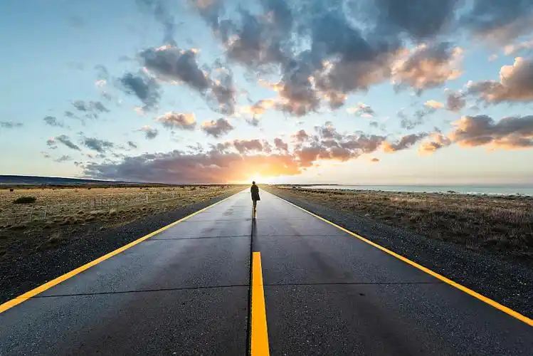 夕阳西下,一个人走在路中间图片下载