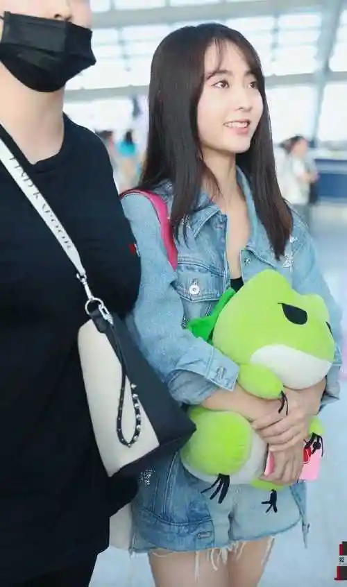 邢菲终于换风格穿紫色开衫配印花衬衫走机场大牌帽子好吸睛