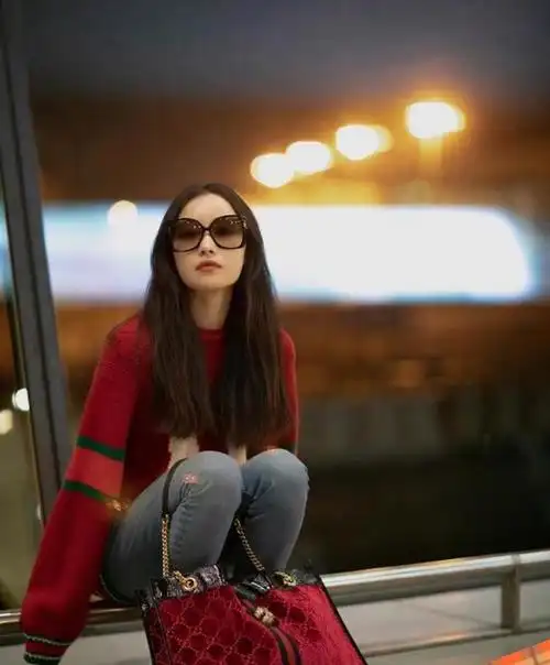 倪妮机场街拍:红色毛衣搭修身蓝色牛仔裤,太宽松了!简约又时尚