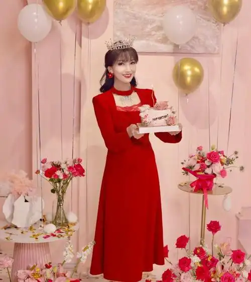 照片中,赵雅芝身着红色的礼服,优雅大方,面带微笑地与周围的人一起