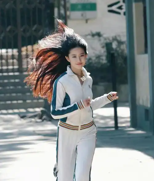 只见刘亦菲身穿白色运动服,搭配白色系运动裤,披着黑长直的秀发,在