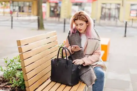 女孩坐在长凳上等待她的朋友照片